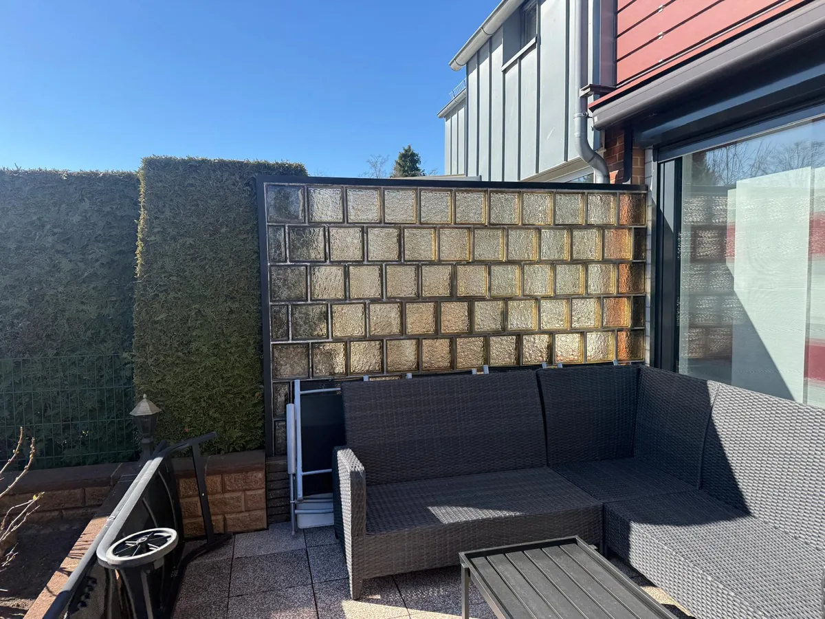 Bisheriger Sitzbereich auf der alten Terrasse vor einer Glasbausteinwand
