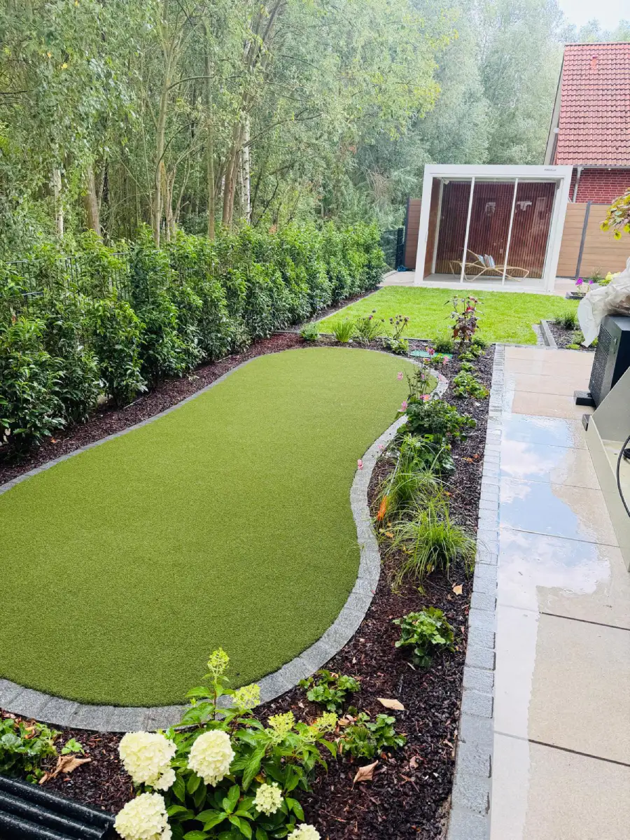 Fertig gestalteter Garten mit Rasen, geschwungenen Beeten, Bepflanzung und Pergola in Hannover